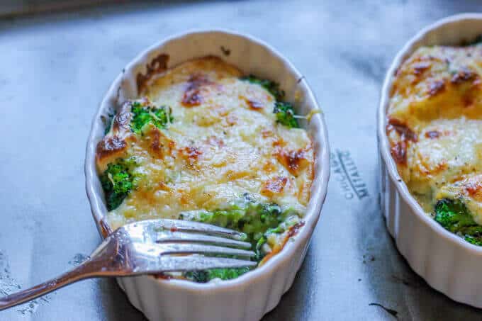 Cheesy Broccoli Au Gratin is a delicious dish that features America's favorite vegetable, topped with amazing cheesy sauce that is baked to perfection. Just a few simple ingredients, mixed with the sophistication of a Gruyere cheese, marry together to make this dish both rustic and elegant. Even broccoli critics can become converts. Cheesy Broccoli Au Gratin in ramekins with fork