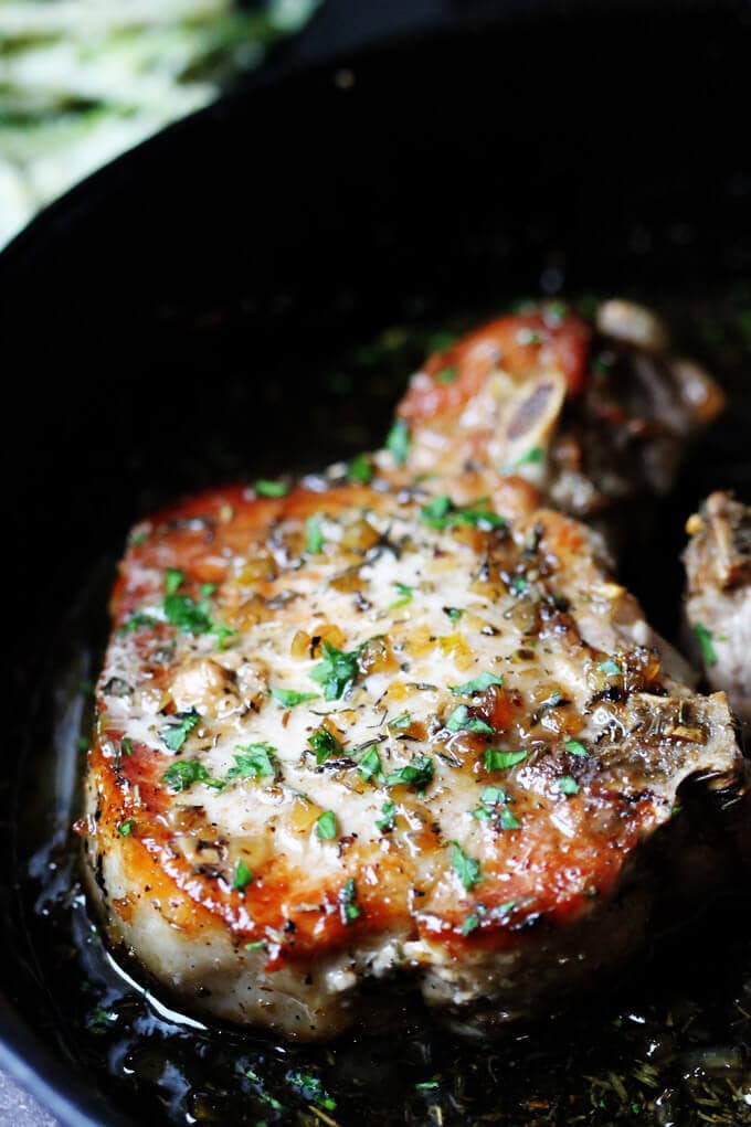 Brown Sugar Pork Chops with Garlic and Herbs are as delicious as they sound. The sweet brown sugar sauce is perfectly balanced by garlic and dried herbs like thyme and oregano. Juicy pork chops dish that comes together in no time. Bone in Brown sugar pork chop with garlic and herbs in a skillet