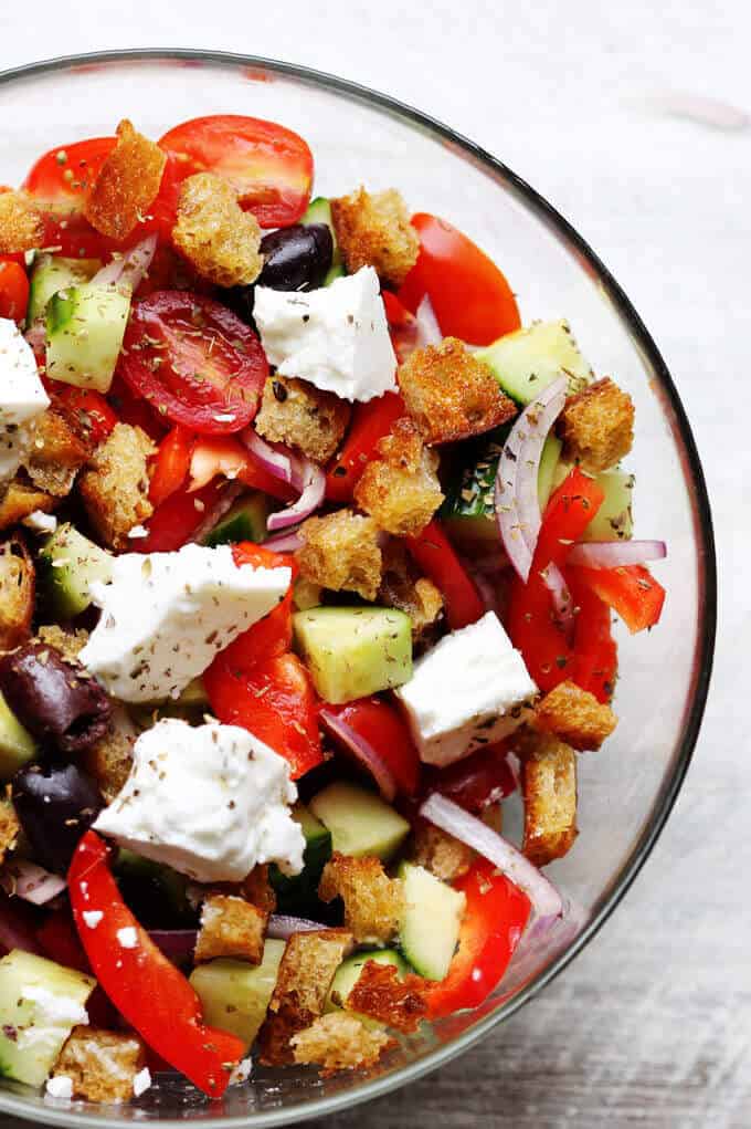 Greek Panzanella Salad combines traditional Greek salad flavors, like Kalamata olives, and tangy feta with bread cubes toasted in tasty garlicky vinaigrette.