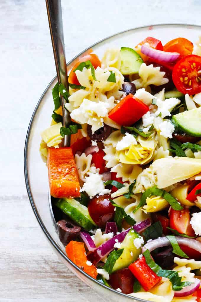 Farfalle Pasta Salad Mediterranean Style is a great pasta salad with super fresh ingredients like cucumbers, tomatoes, onions and peppers. Extra flavors come form Kalamata Olives, marinated artichokes and feta cheese. Dressed with red wine based vinaigrette instead of mayo makes for super light and refreshing side dish.