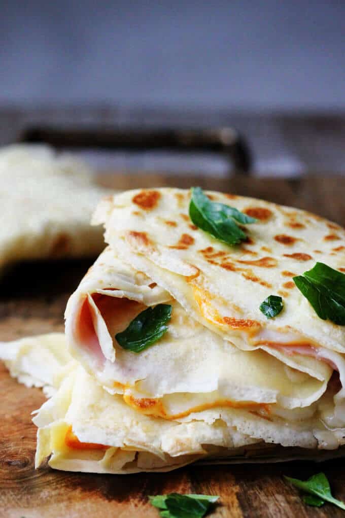 Ham and Cheese Crepes are one of the most famous French street foods. Simple batter from flour, milk, eggs and butter can make amazing perfect crepes. Fill them up with sliced ham and melting cheese and you can feel like on the corner of the French street.