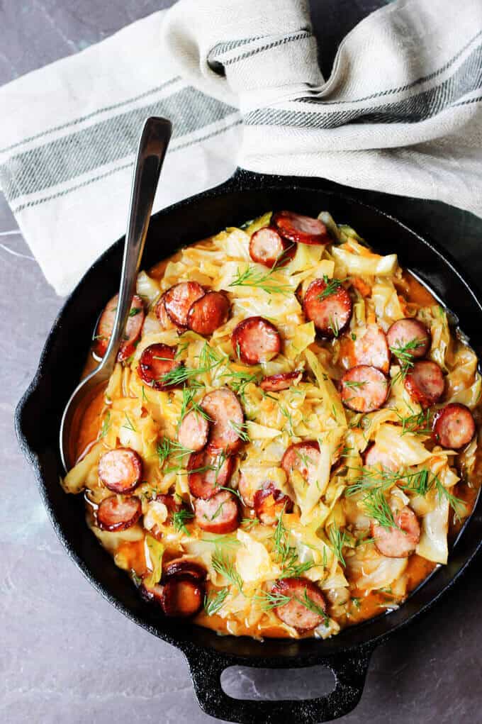 Kielbasa and Cabbage is a perfect Polish summer hunter's stew. It's made from young cabbage w/ the addition of Polish sausage and dill. Kielbasa and Cabbage in a skillet with kitchen towel