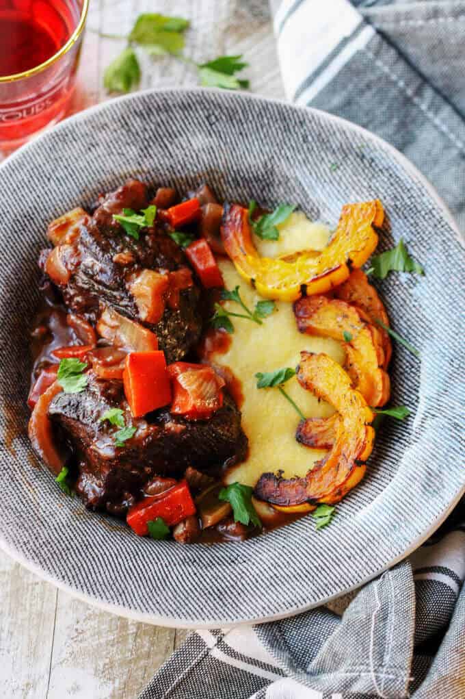 Red Wine Braised Short Ribs with Parmesan Polenta and Roasted Delicata Squash, is a super flavorful dinner idea that will make you feel warm and cozy on a cold, winter night.