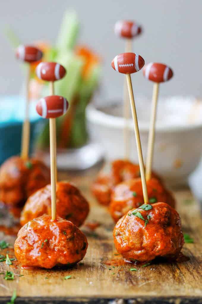 Buffalo Turkey Meatballs on a board with football sticks