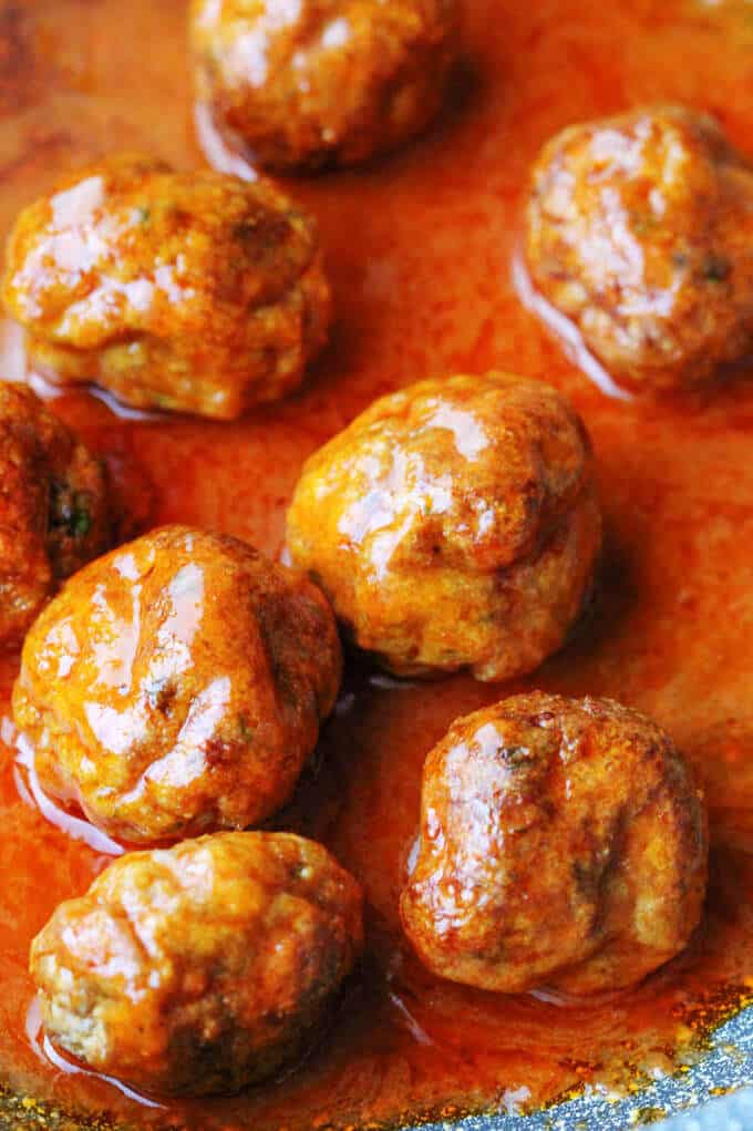 Buffalo Turkey Meatballs are a perfect appetizer for the Big Game. They're also a lighter alternative to a traditional chicken buffalo wings, not only because they have less fat, but also because they're baked, not fried. Not to mention they're also super easy to make. Buffalo Turkey Meatballs in a sauce on a pan