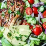 Garlic Lemon Chicen Salad with lettuce, tomatoes, cucumber, onions, avocado; vertical