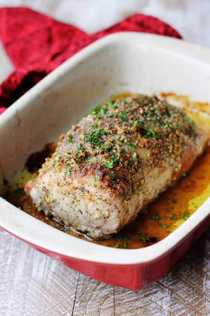 Brown sugar pork loin in the baking dish with red napkin in the back