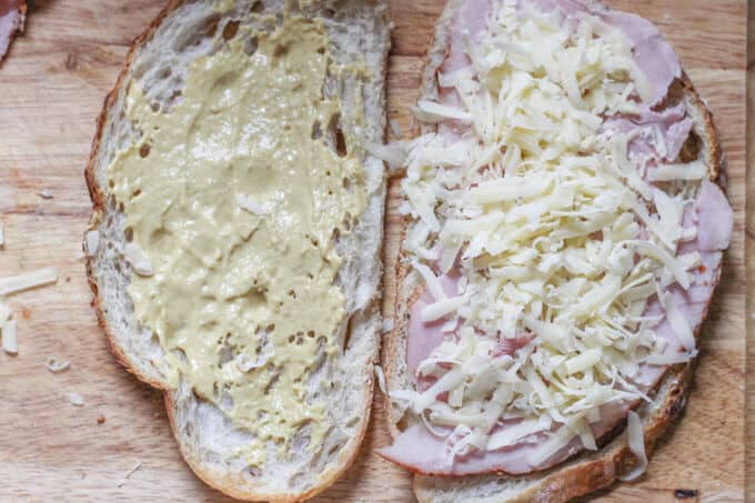 This Classic Croque Monsieur Recipe is easy to prepare and is a taste emersion right to the middle of Paris. For this recipe you can use any type of ham; so by all means, feel free to use any leftovers that you may have from this Easter. Two slices of bread, one with mustard, the other with ham and shredded cheese
