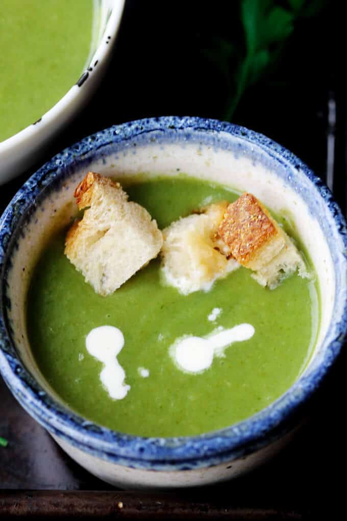 This Creamy Spinach Soup with Parmesan Croutons is very easy, healthy and by far the best spinach soup I've eaten. Not to mention, with a few simple substitutions it can even be transformed into a vegan soup. Creamy spinach soup with croutons and dollop of cream in a bowl
