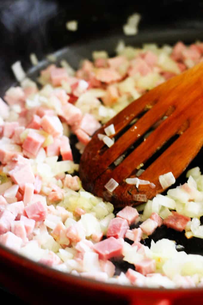 This Ham and Cheese Soup with White Wine and Gruyere is yet another recipe to show you how easily you can repurpose your leftover ham. This soup is rich and decadent, and it will keep your loved ones coming back for seconds...guaranteed. ham and onions sautéed on a pan