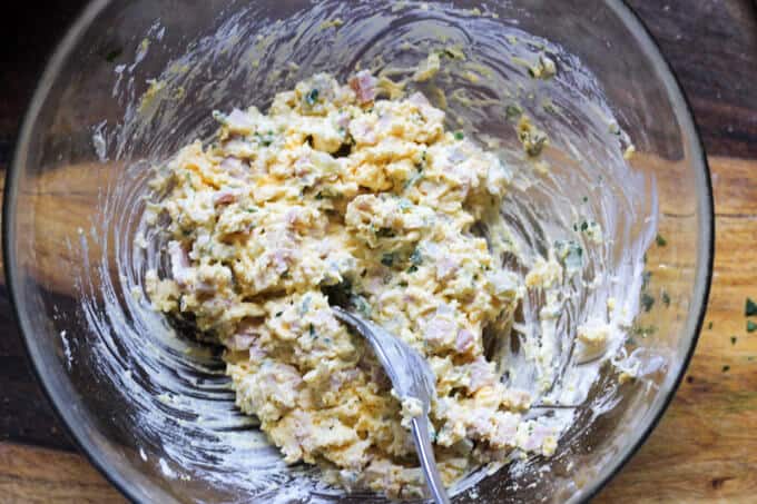 Stuffed Eggs with Ham & Cheese, sprinkled with a dash of Spanish Smoked Paprika, are super meaty, cheesy and satisfying. The subtle heat from the smoked paprika marries everything together to create a perfect egg bite. These are a MUST for your Easter table stuffing for eggs mixed in a bowl