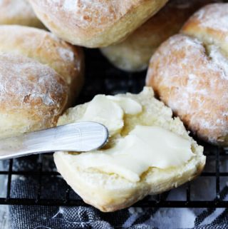 Breakfast rolls with one cut up and with spreader butter