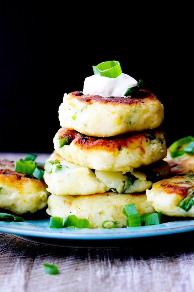 Potato cutlets stack on a blue plate with black background