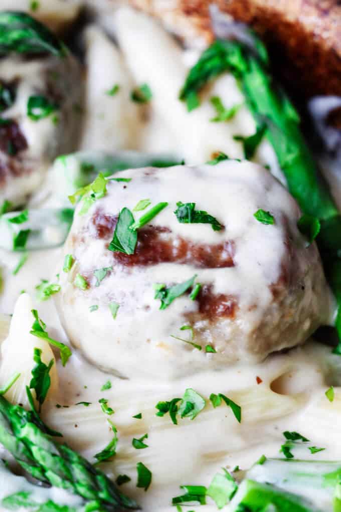This Turkey Meatballs Alfredo Pasta with Asparagus is a perfect midweek dinner, for nights when you're short on time but still want to make your family a hearty meal. It comes together quickly and incorporates a store-bought Alfredo sauce shortcut. Turkey meatball in alfredo sauce, close up