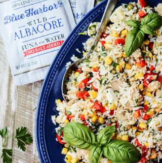 Italian Rice Salad with Tuna on a blue plate with tuna pouches on a side
