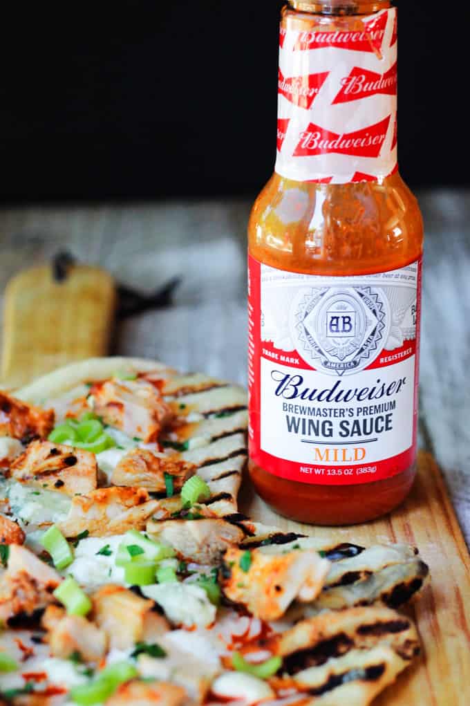 Buffalo wing sauce with pizza on a side