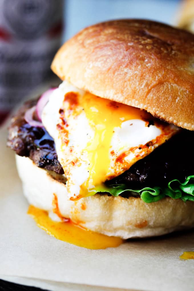 Smoky BBQ Burger with Garlic Aioli & Fried Egg is a perfect summer meal that uses Budweiser Sweet & Smoky BBQ sauce, beef patties, fried eggs, pickled onions and garlic aioli. Smoky burger with runny egg yolk