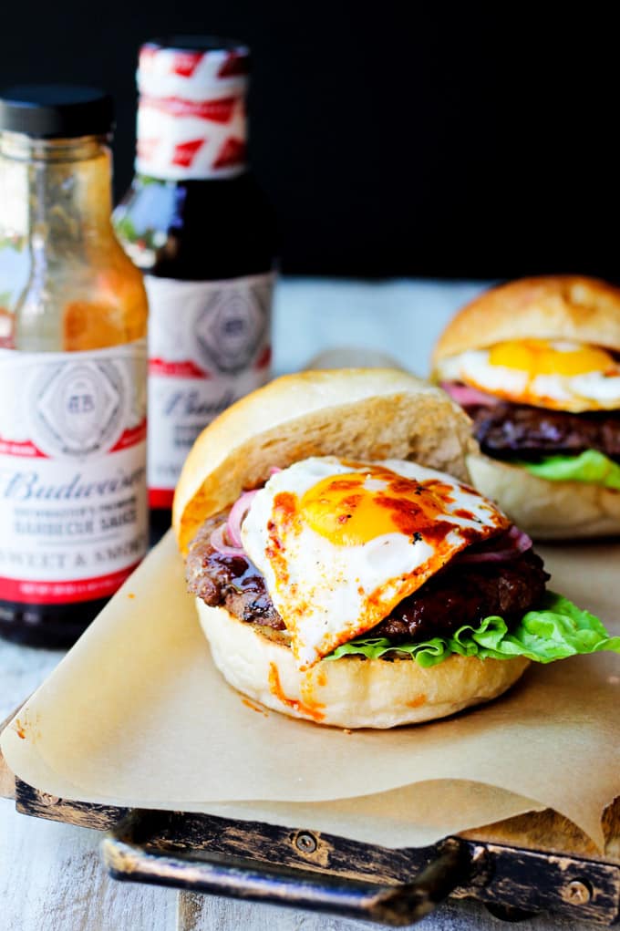Smoky BBQ Burger with Garlic Aioli & Fried Egg is a perfect summer meal that uses Budweiser Sweet & Smoky BBQ sauce, beef patties, fried eggs, pickled onions and garlic aioli. Smoky BBQ Burgers with Budweiser sauces