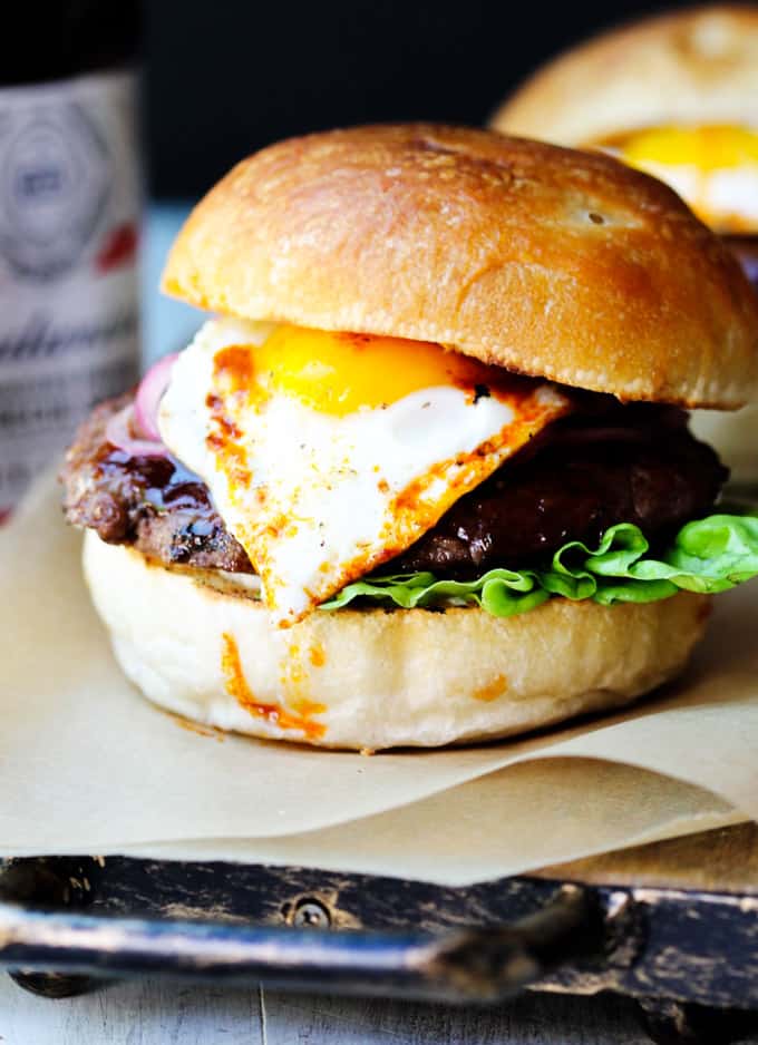 Smoky BBQ Burger with Garlic Aioli & Fried Egg is a perfect summer meal that uses Budweiser Sweet & Smoky BBQ sauce, beef patties, fried eggs, pickled onions and garlic aioli. Smoky Burger with fried egg