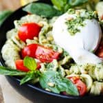 Burrata Cheese on top of pesto pasta with cherry tomatoes