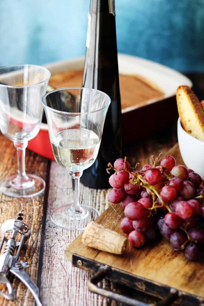 Italian Dessert Wine Moscato D'Asti in a glass with grapes and desserts on a side.