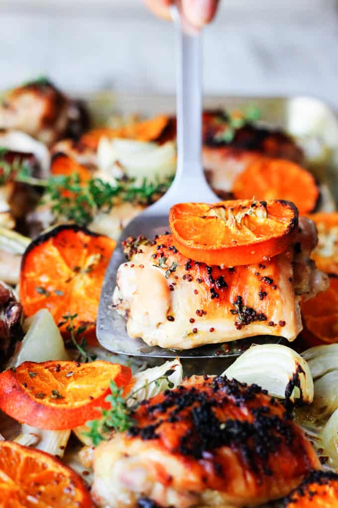 Spatula picking up mustard chicken with clementine