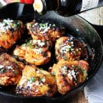 Olive Oil Chicken Mediterranean Style in a skillet with oil pouring over