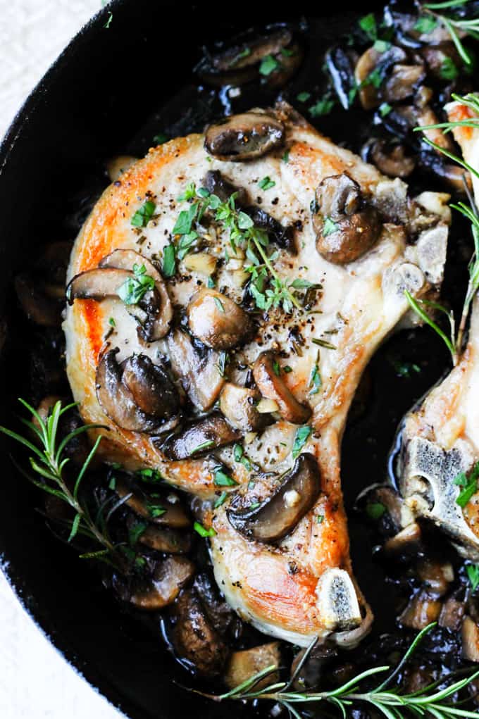 Pork chops with garlic butter mushrooms in a skillet