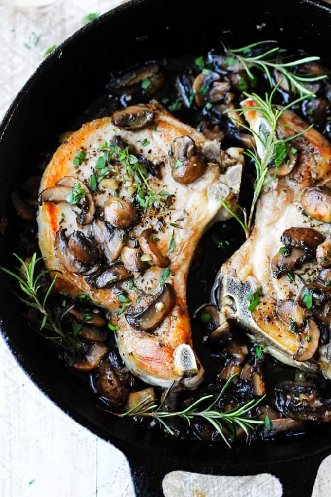 bone-in pork chops in a skillet with mushrooms