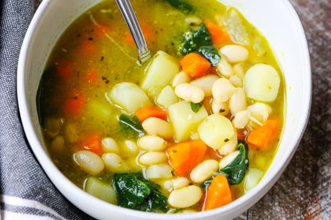 Bean Soup with spinach and pesto from pressure cooker served in a bowl