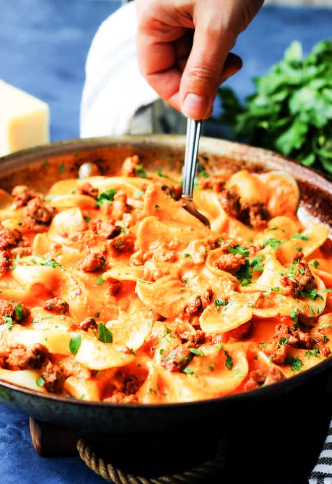 Serving pasta alla vodka with spicy sausage