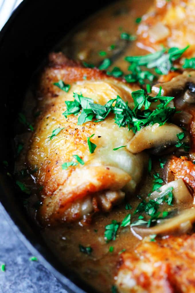 Close up of French chicken chasseur in a skillet with parsley