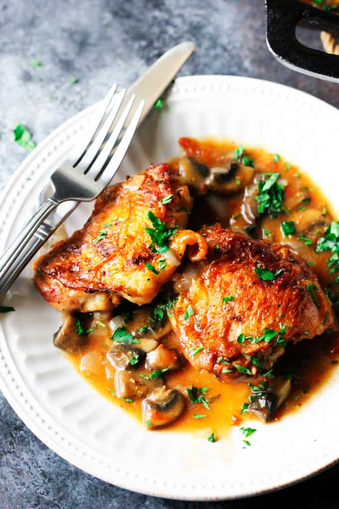 French Hunters Chicken on w white plate with fork and knife