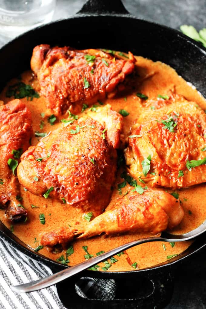 Hungarian Chicken Paprikash is a traditional Hungarian dish made from simple, real food ingredients. Succulent pieces of chicken are simmered in the most flavorful sauce made with the best Hungarian Paprika and a cream. Serve it with noodles or potatoes and you'll have truly amazing comfort food that you'll want to have over and over again. Chicken Paprikash in a skillet with a spoon.