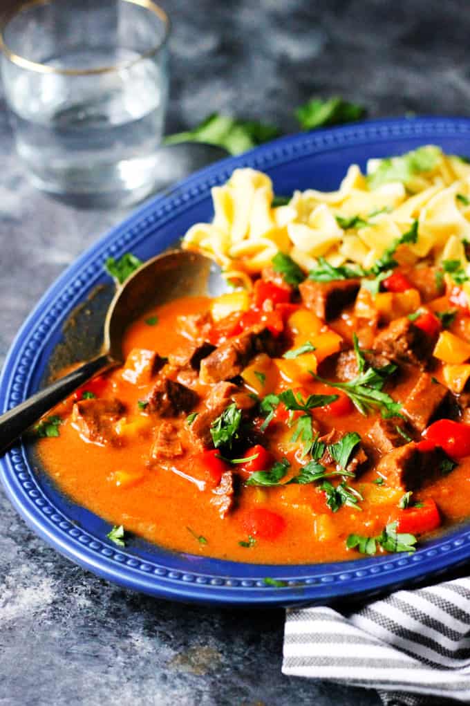 Authentic Hungarian Goulash with paprika on a serving platter with noodles