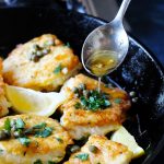 Pan Fried Cod in a cast iron skillet with Meuniere Sauce spooned over