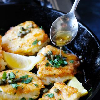 Pan Fried Cod in a cast iron skillet with Meuniere Sauce spooned over