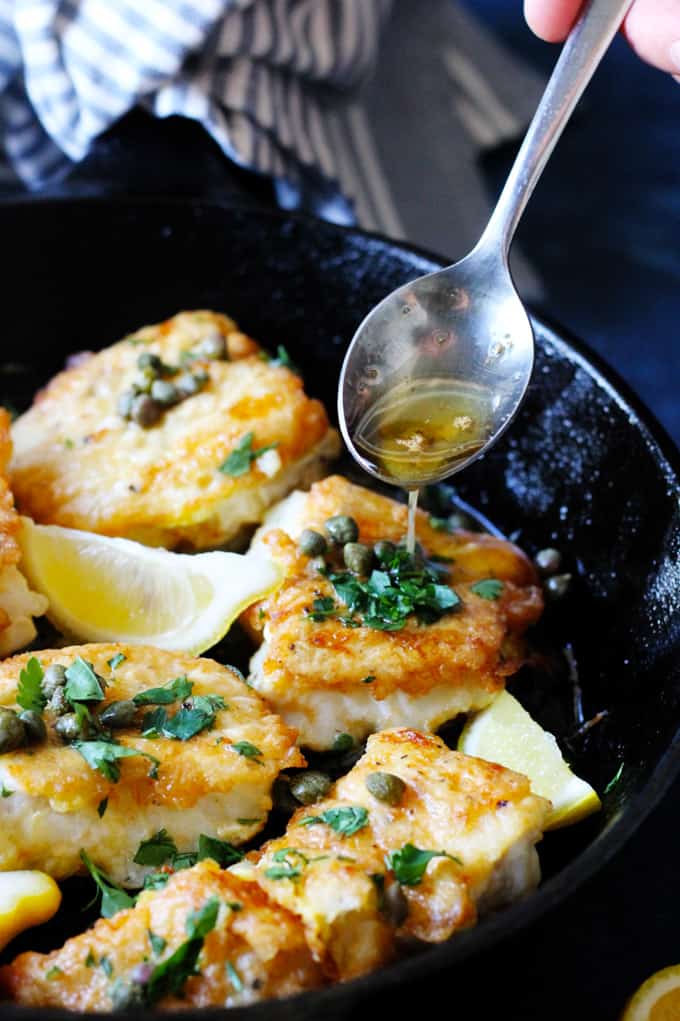 This Pan Fried Cod with Meuniere Sauce comes together in just 15 minutes! No gimmicks...it really is super simple. With just a few steps and your dinner is ready. And it will wow your kitchen patrons. Pan Fried Cod in a cast iron skillet with Meuniere Sauce spooned over