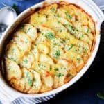 Boulangere Potatoes in white baking dish with spoon on a side