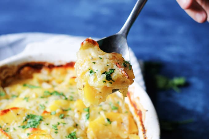 Spoon picking up French potatoes with onions