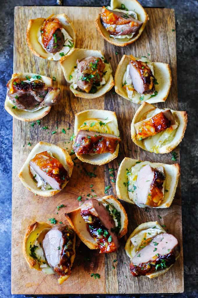 Tea Infused Orange Duck Bites with Brie are a perfect appetizer for Easter or any other Holidays. They are full of flavor with Stash Lemon Ginger Tea infused duck breast, seared to perfection, smothered with Lemon Ginger Tea Orange Glaze and topped on the melted brie toasts for the ultimate bite. Tea Infused Orange Duck Bites on a Serving Board