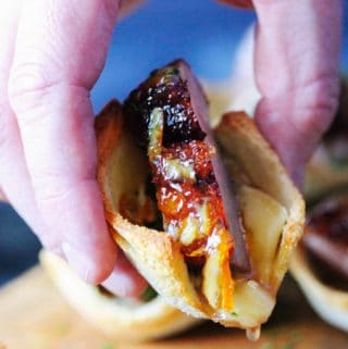 Horizontal shot of picking up an orange duck bite with brie