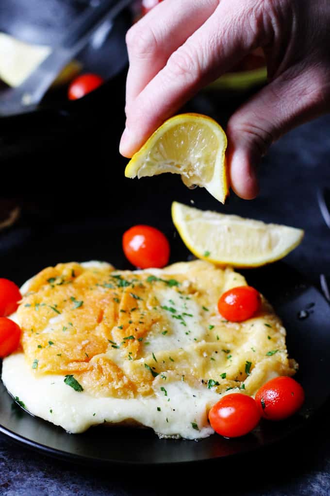 Squeezing Lemon Wedge over the Saganaki Cheese