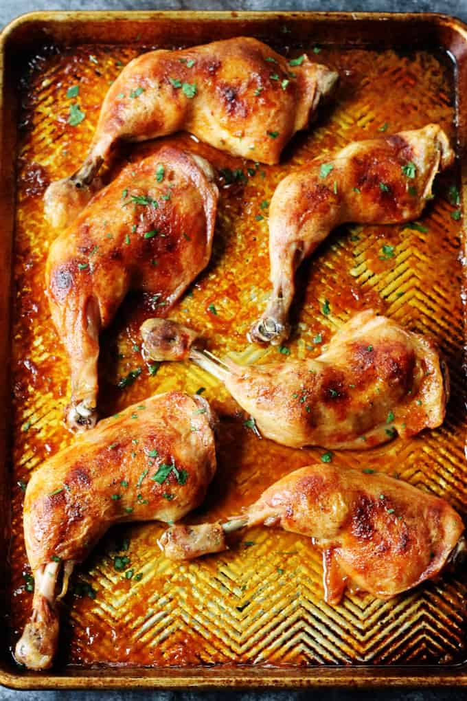 Slow roasted chicken leg quarters on a sheet pan