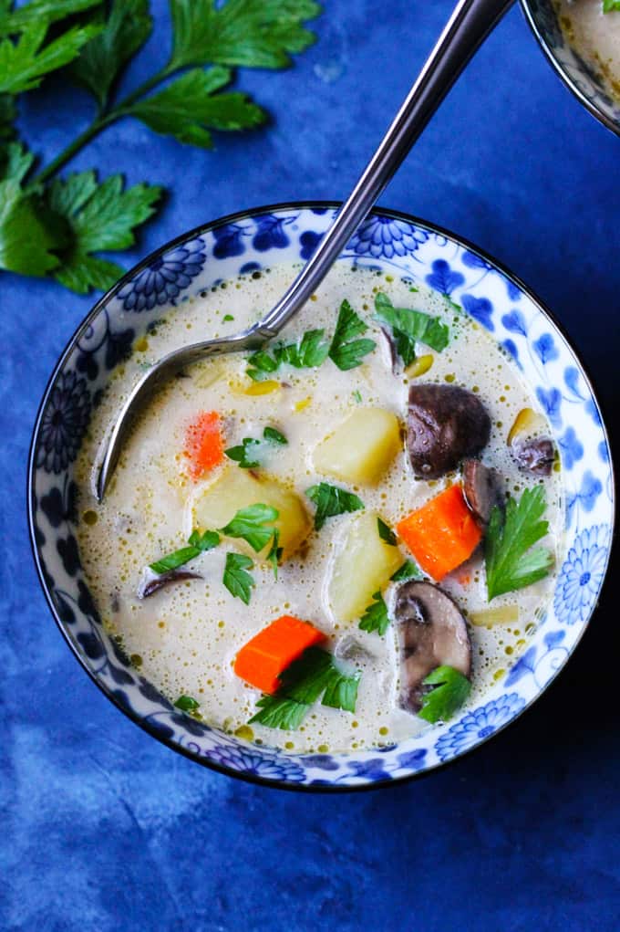 Polish Mushroom Soup in a bowl with spoon on a blue background