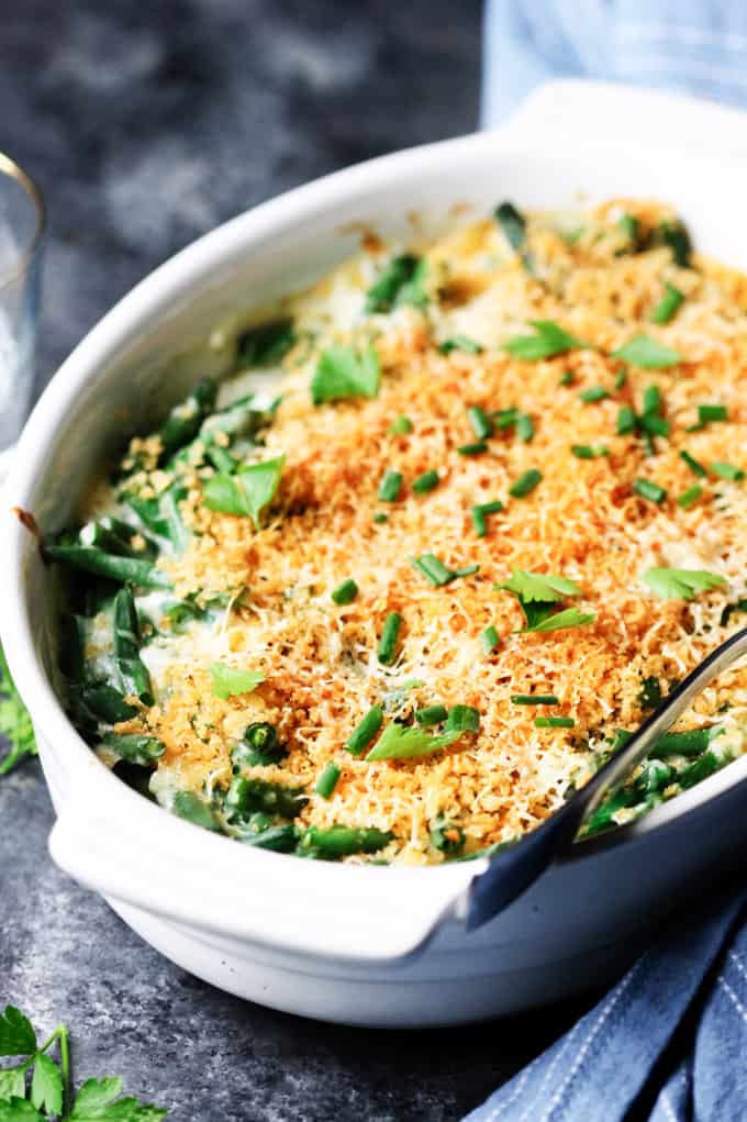 Green bean casserole in a white dish with spoon