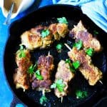 Breaded pork on skewers in cast iron pan
