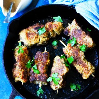 Breaded pork on skewers in cast iron pan