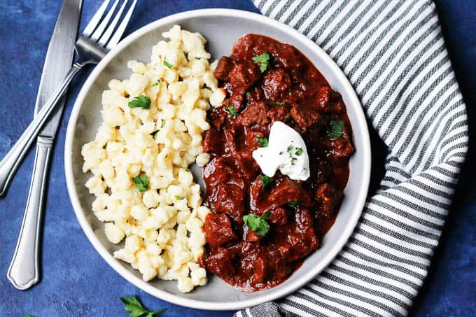 Hungarian Porkolt Goulash on a plate with egg noodles
