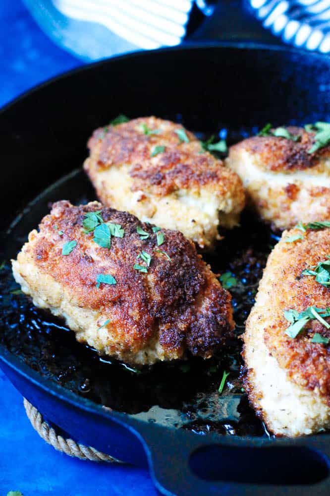 Rolled fried chicken cutlets with compound butter (chicken kiev) in a skillet